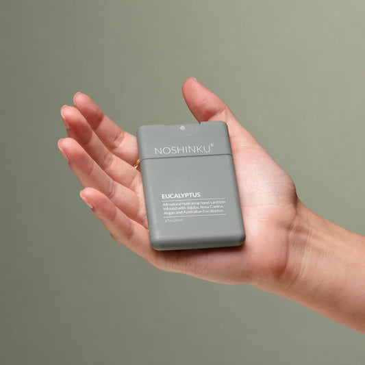 Hand holding Noshinku Eucalyptus refillable moisturizing hand sanitizer spray for everyday travel-friendly use. Exclusively at Area Boutique.