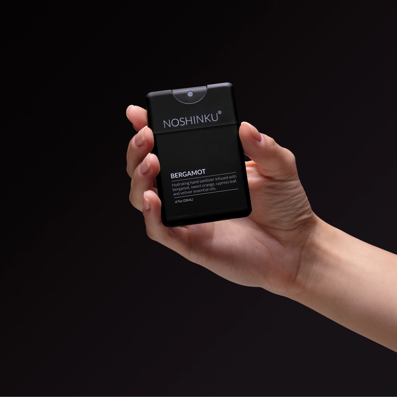 Hand holding Noshinku Bergamot refillable moisturizing hand sanitizer spray for everyday travel-friendly use. Exclusively at Area Boutique.