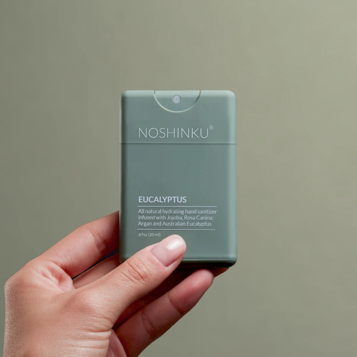 Hand holding Noshinku Eucalyptus refillable moisturizing hand sanitizer spray with Australian eucalyptus essential oils. Exclusively at Area Boutique.