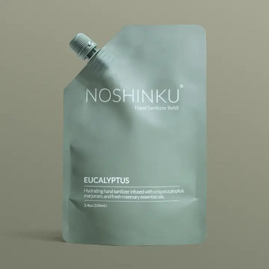 Noshinku Eucalyptus Hand Sanitizer Refill Pouch in muted sage green packaging with a screw cap, featuring a hydrating refill formula infused with eucalyptus essential oils.