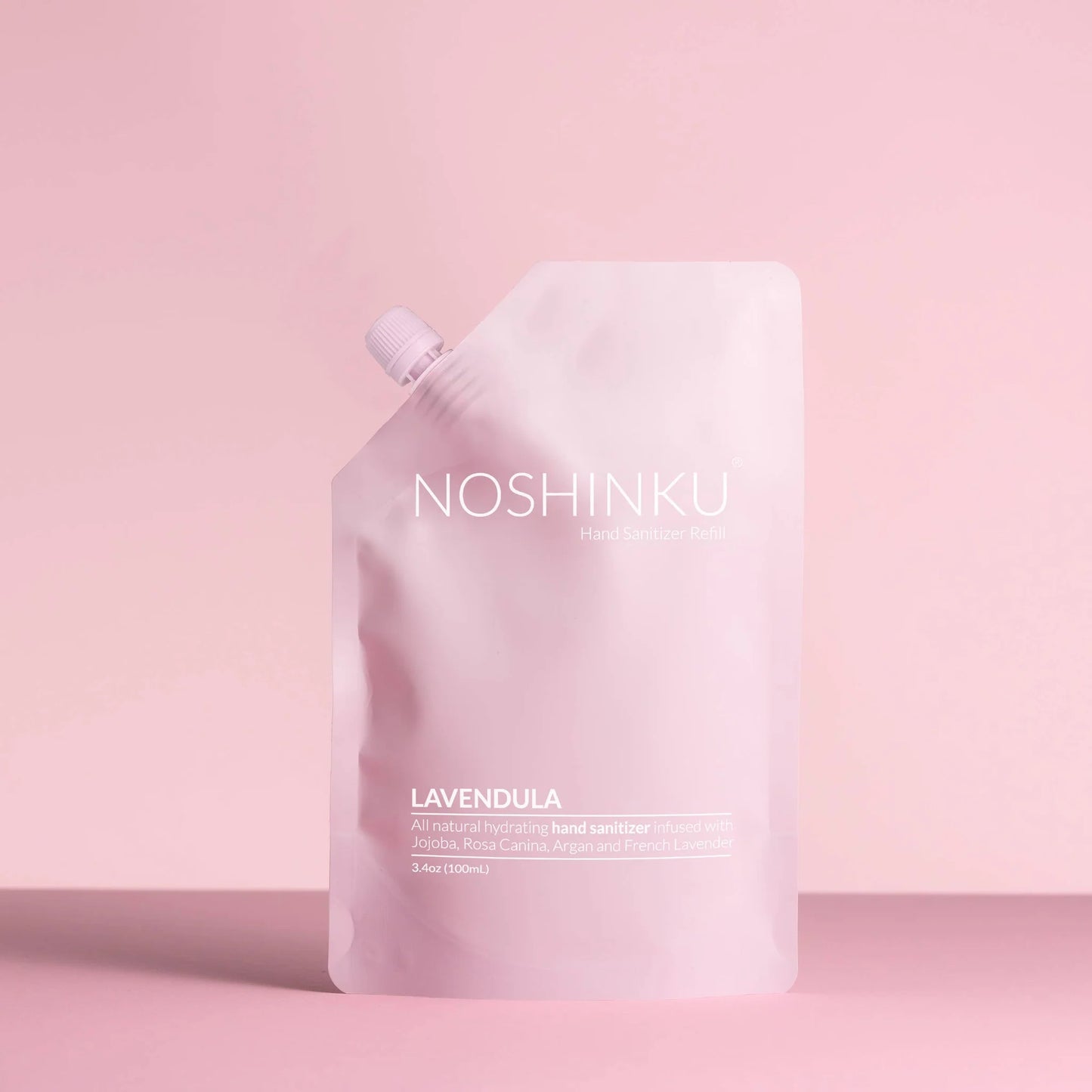 Noshinku Lavendula hand sanitizer refill pouch in soft pink packaging against a pastel pink background.