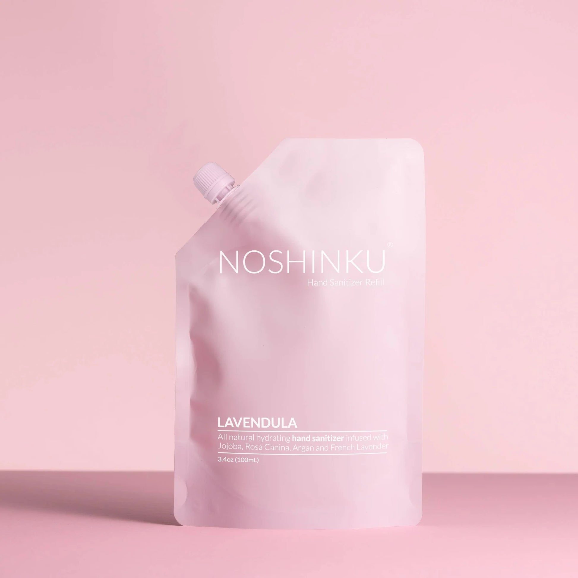 Noshinku Lavendula hand sanitizer refill pouch in soft pink packaging against a pastel pink background.