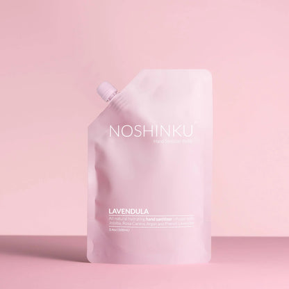 Noshinku Lavendula hand sanitizer refill pouch in soft pink packaging against a pastel pink background.