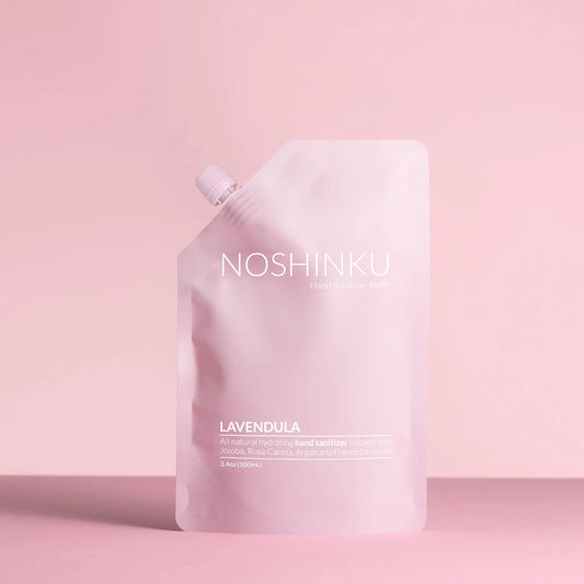 Noshinku Lavendula hand sanitizer refill pouch in soft pink packaging against a pastel pink background.