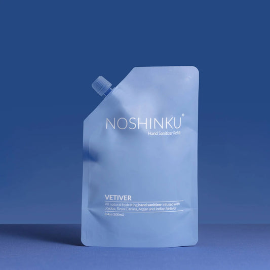 Noshinku Vetiver Hand Sanitizer Refill Pouch in soft blue minimalist packaging with a screw-top cap against a deep blue background.